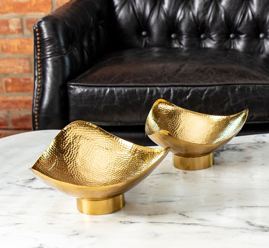 Hammered brass bowls on a white marble coffee table