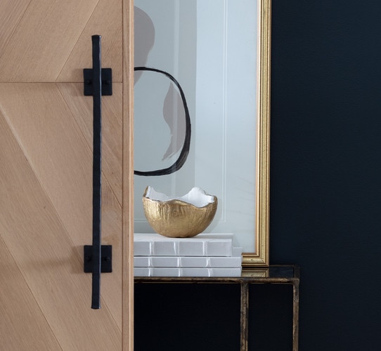 Brass and white bowl resting on three books in front of a large gold picture frame