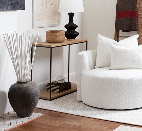 living room corner with a wood and metal console table and white swivel chair