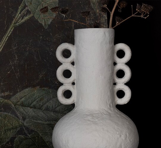 Textured brown metal vase with a stick coming from throughout