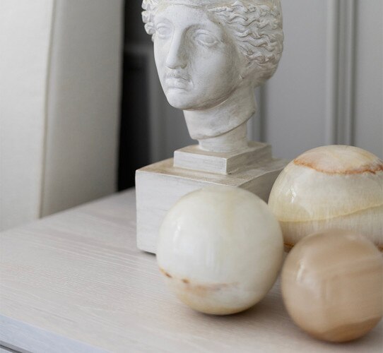 Jade decorative sphere's beside a bust on a bedside table