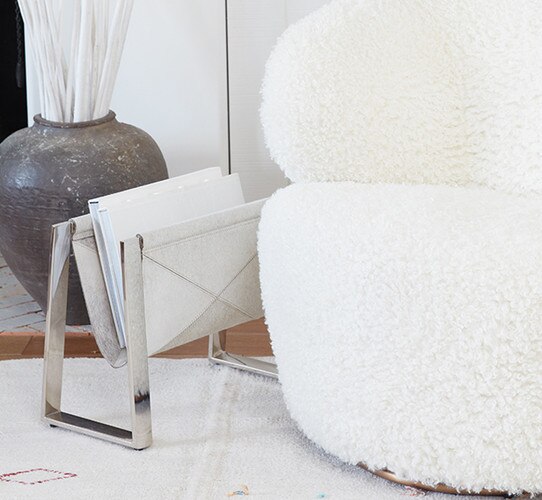 White swivel chair beside a magazine rack