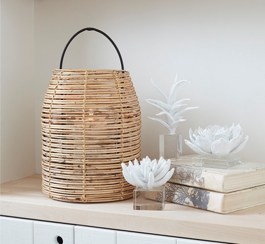 Rattan hurricane next to three resin succulent sculptures