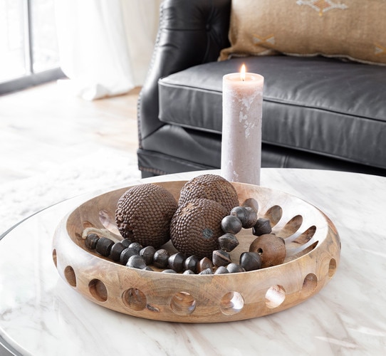 Large wooden bowl holding decorative sculptures