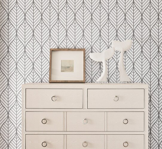 White dresser with a wooden picture frame and whale tail sculptures
