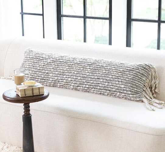 Large textured bolster pillow on a white sofa