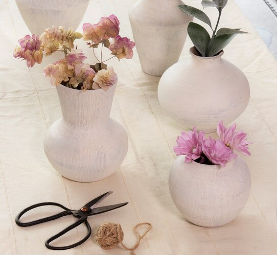 White ceramic vases holding pink and white flowers