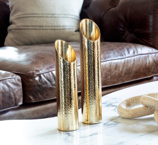 Hammered metal candle holders sitting on a marble coffee table