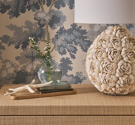 Woven side table with a marble tray and shell lamp