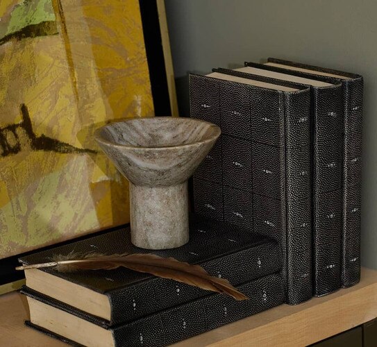 Marble bowl sitting atop leather bound books