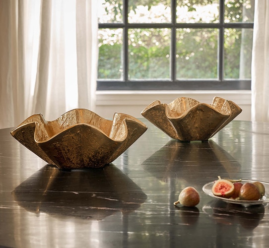 Two metal bowls resting on a dining room table