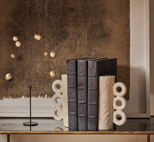 Three leather books held up by a brown metal bookends