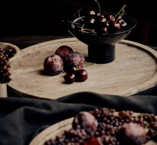 Marble decorative tray holding cherries and a bowl