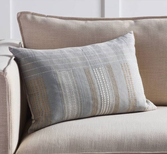 Gray lumbar pillow on cream couch