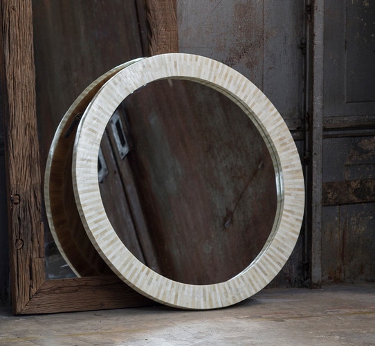 Bone mirror resting against a concrete floor