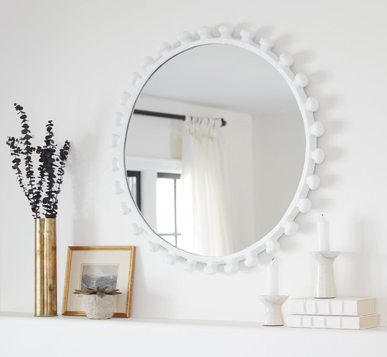 White mirror above a decorated mantle