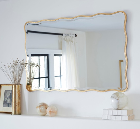Rectangular mirror hung above a decorated mantle