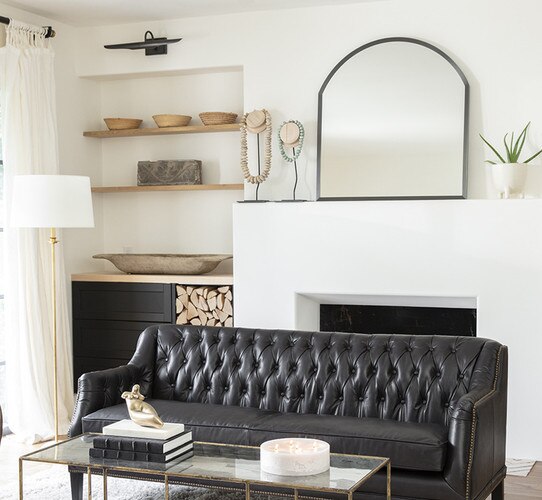 Living room with leather sofa coffee table and mantle mirror