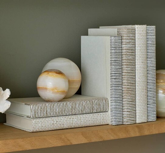 White leather books holding marble spheres