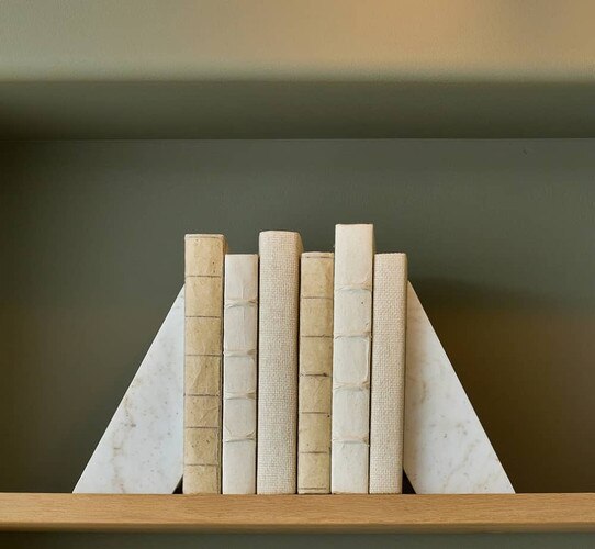 White decorative books between marble bookends