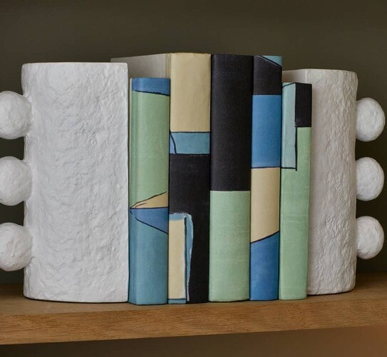 Multi colored books between white bookends