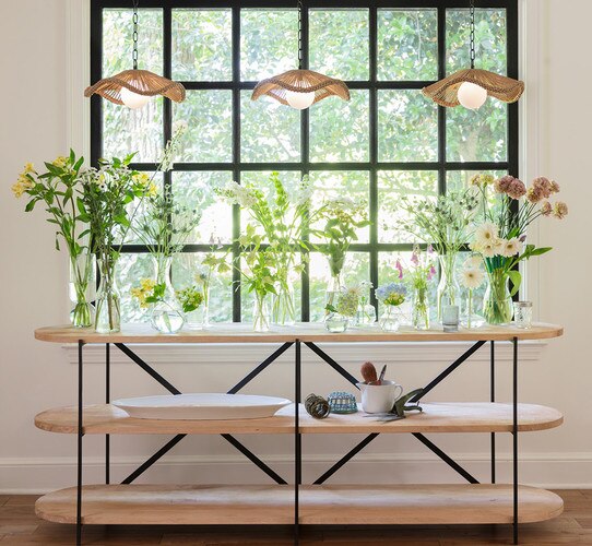 Wood and metal console table full of vases with flowers