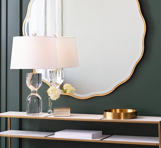Brass and stone console table with a lamp and brass tray on top