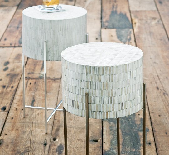 Bone drum table with polished nickel legs on a wood floor