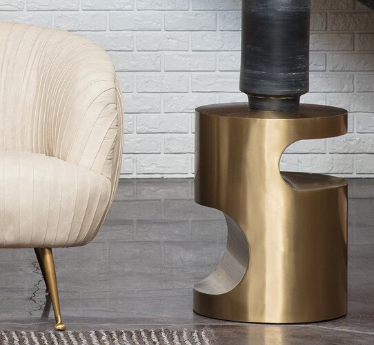 Brass side table beside a white leather chair