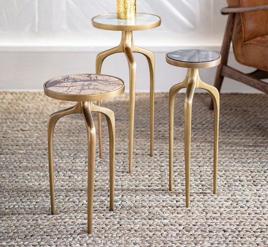 Brass nesting tables beside a leather chair