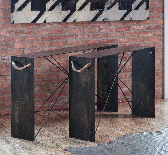 Metal and wood console tables under a large painting