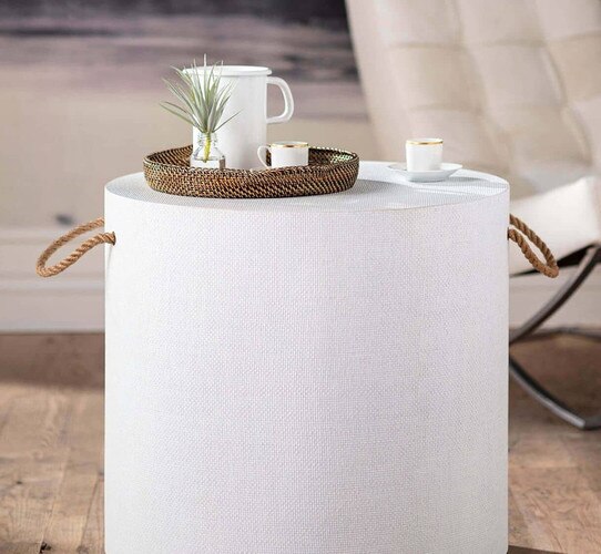 White side table with woven handles holding a tray with tea cups and a small vase