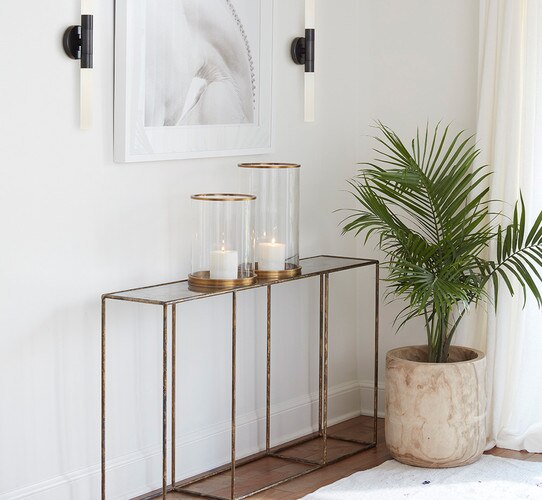Metal console table holding hurricane candle holders