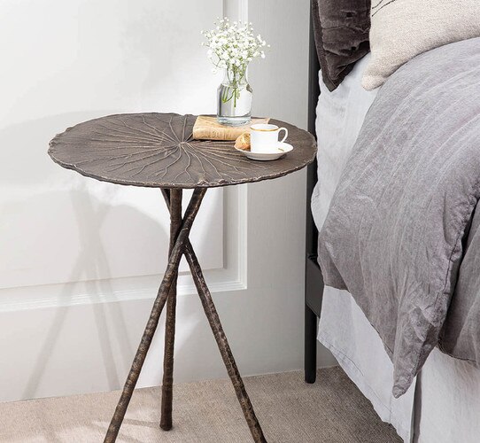 Lily pad metal side table beside a bed