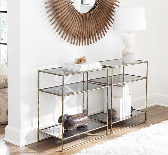 Two metal console tables under a wooden mirror