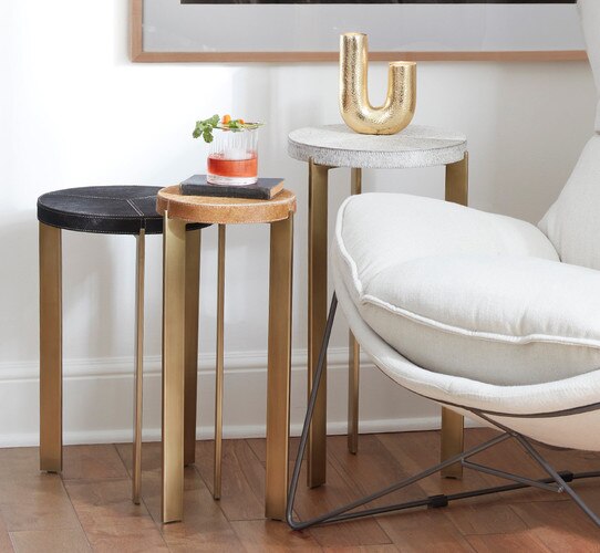 Nexting brass tables beside a white chair