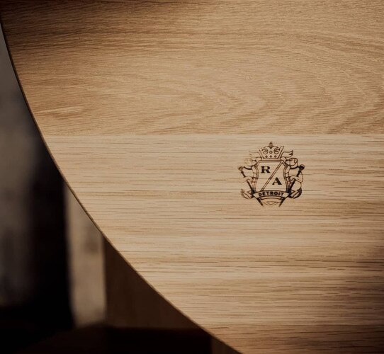 Regina Andrew crest burned int bottom of a wood coffee table