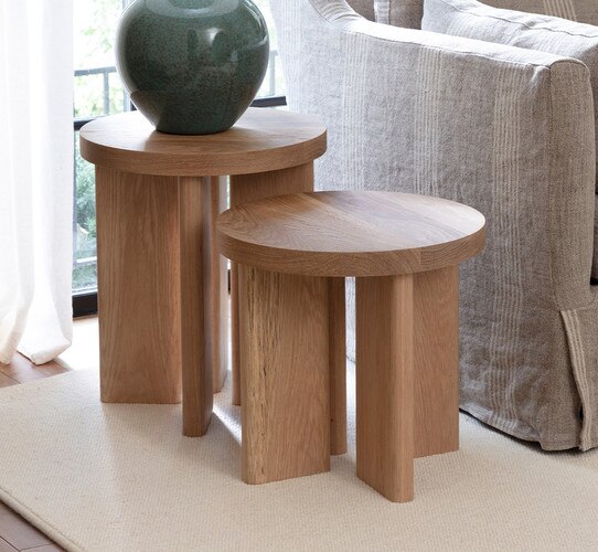 Wood side tables holding a lamp next to a brown sofa