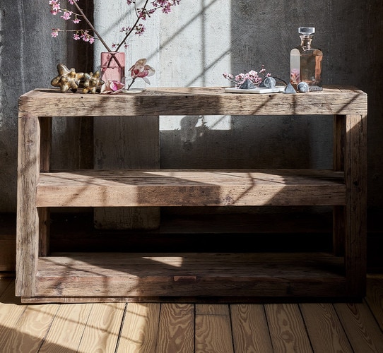 Wood two shelved console table holding pink vases