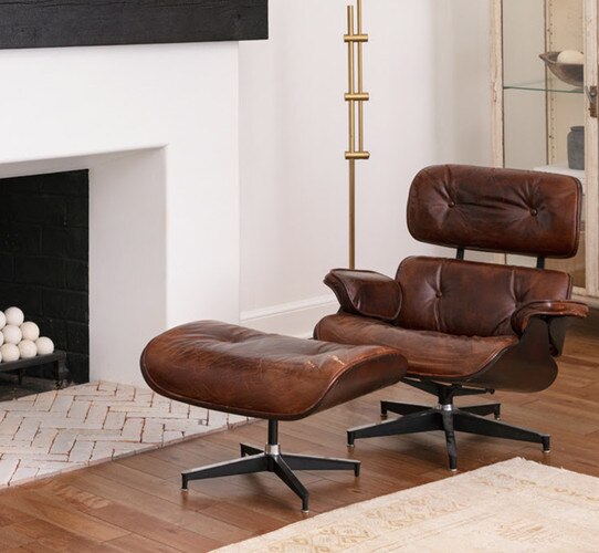 Leather lounge chair with a foot rest beside a fireplace