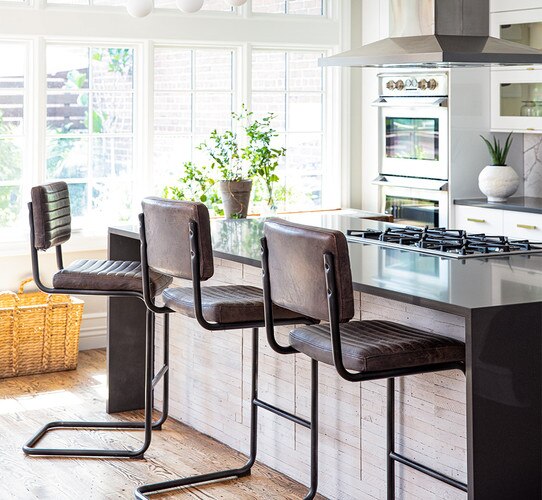 Three leather counter stools next to a kitchen island