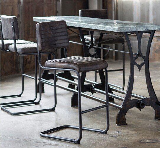 Leather and metal counter stool next to metal bar table