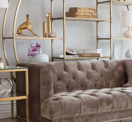 Velvet sofa in front of a large metal etagere