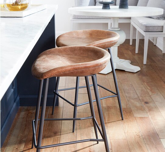 Leather bar stool next to blue kitchen island