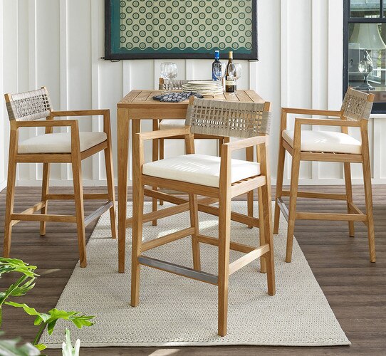 Patio with wood bar table and four wooden chairs around it