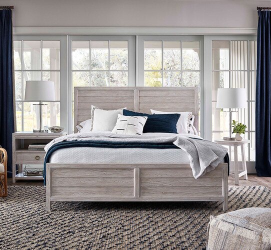 Bedroom with gray wood bed frame and two side tables holding lamps