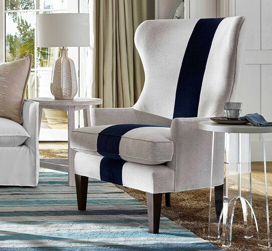 High backed gray and blue chair beside an acrylic side table