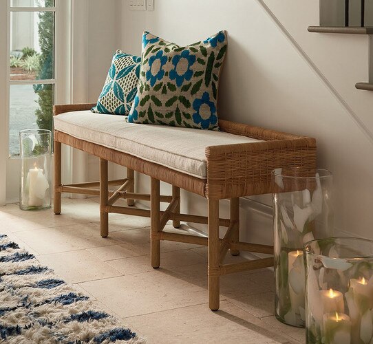 Rattan bench with pillows on top in an entryway