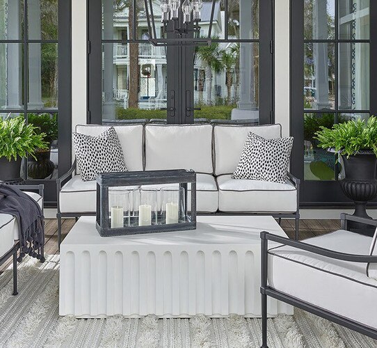 Patio with white and black furniture around a concrete coffee table