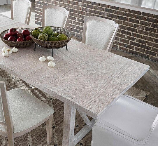 White dining room table with two bowls of artichokes and onions atop it